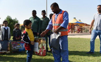 بلدية بقيق تشارك أطفال روضة زهور البراعم بتوزيع كسوة الشتاء على عمال النظافة والزراعة