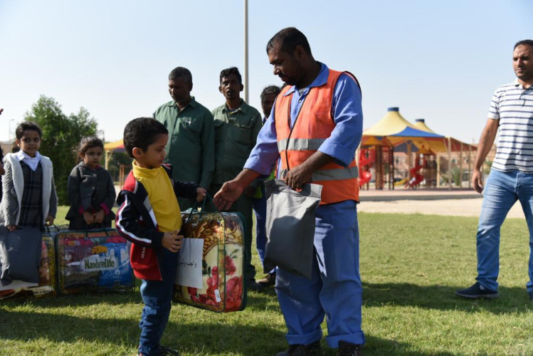 بلدية بقيق تشارك أطفال روضة زهور البراعم بتوزيع كسوة الشتاء على عمال النظافة والزراعة
